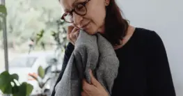 Leder erkennen Geruch: Eine Hand hält ein Stück glattes Leder zum Riechen und Fühlen, um die Qualität zu prüfen.
