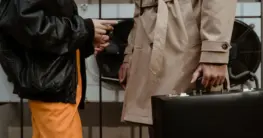 Leder-Trenchcoat in klassischem Beige, mit Gürtel und doppelter Knopfleiste, elegant kombiniert.