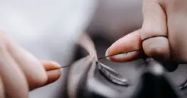 Lederjacke Naht reparieren – Eine Lederjacke Naht reparieren mit Nadel und Faden – Fokus auf die Handarbeit