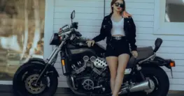 Lederjacke Shorts Damen Styling: Eine schwarze Bikerjacke kombiniert mit Denim-Shorts und T-Shirt für einen lässigen Sommer-Look.