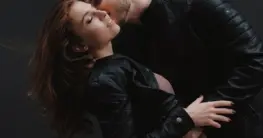 Lederjacke Hochzeit Gast: Elegante schwarze Bikerjacke über einem festlichen Kleid für einen stilvollen Auftritt