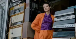 Nachhaltig Second-Hand Lederjacke in Braun vor einer Vintage-Kulisse, die Langlebigkeit und Umweltbewusstsein symbolisiert.