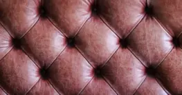Leder Farbe verblasst: Eine dunkelbraune, alte Lederjacke mit deutlich ausgebleichten Stellen an Ärmeln und Schultern, die Pflege benötigt.