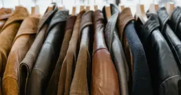 Lederjacke imprägnieren trocknen: eine schwarze Bikerjacke hängt zum Lufttrocknen an einem breiten Bügel
