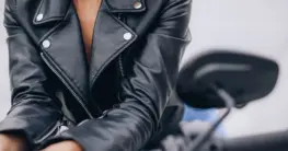 Lederjacke pflegen Hausmittel: Eine dunkle Glattlederjacke wird mit einem Tuch gereinigt, um Hausmittel anzuwenden.