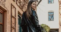 Lederjacke Proportionen: Eine Frau probiert verschiedene Jacken für die perfekte Passform an.