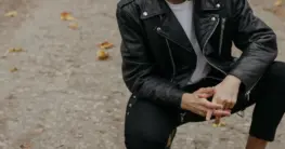 Lederjacke Schuhe kombinieren: Eine schwarze Bikerjacke mit weißen Sneakers für einen lässigen Streetstyle-Look