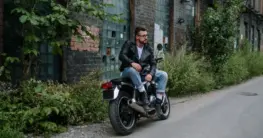 Vintage Bikerjacke – Eine Person trägt eine dunkelbraune Vintage Bikerjacke aus robustem Leder, die Patina zeigt und einen authentischen Stil hat.